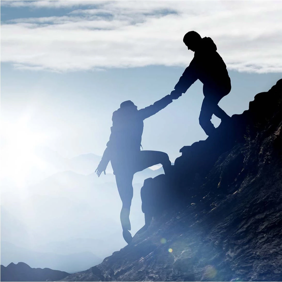 Zwei Personen helfen sich beim Bergseiten auf
